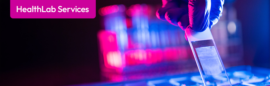 Image of a blue gloved hand conducting a medical test in a dark laboratory.